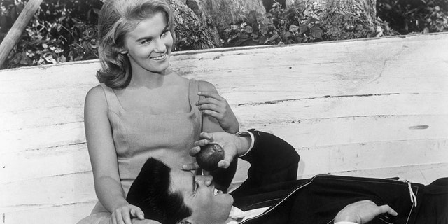 Elvis Presley smiling and laying on Ann-Margrets lap