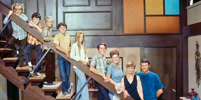 The cast of the Brady Bunch posting on the steps