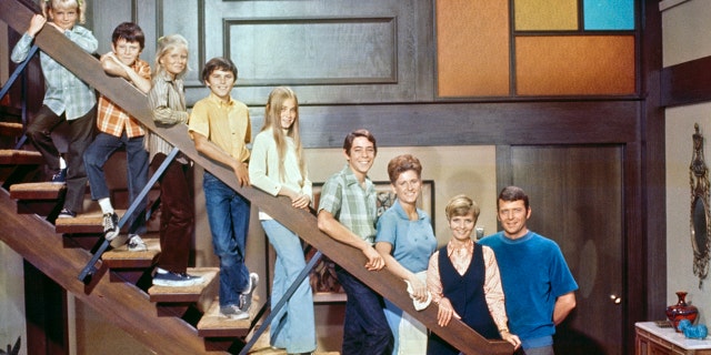 The cast of the Brady Bunch posting on the steps