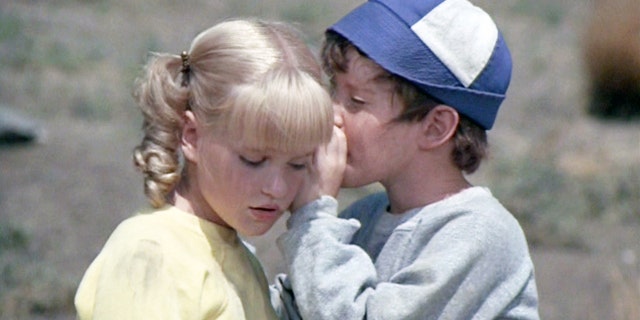 Mike Lookinland as Bobby Brady whispering in Susan Olsens ear, who is playing Cindy Brady