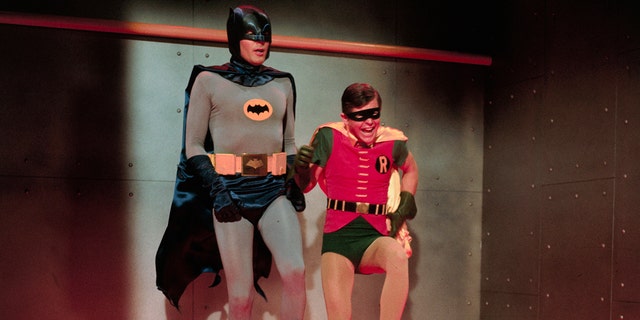 Batman and Robin in costume hopping around