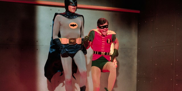 Batman and Robin in costume hopping around