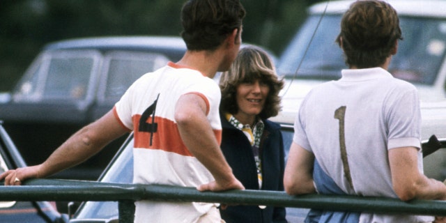 Prince Charles wears white shirt and slacks while speaking with Camilla at polo match