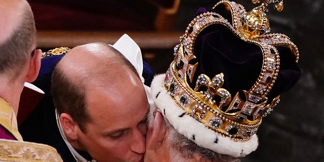 A close-up of Prince William kissing his father King Charles