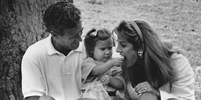 Denise Austin getting fed by her daughter in a black and white photo