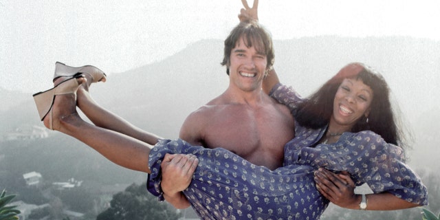 Arnold Schwarzenegger holding up Donna Summer