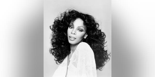 A black and white photo of donna summer wearing a white dress