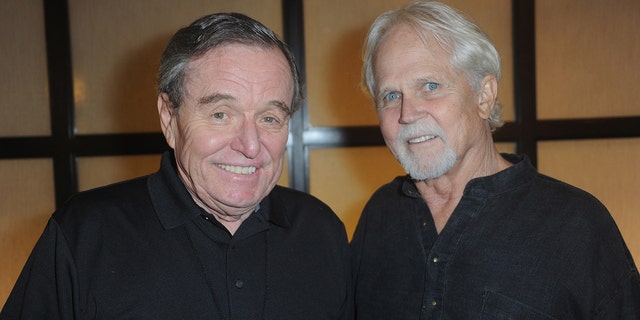 Jerry Mathers and Tony Dow both wearing black and smiling next to each other