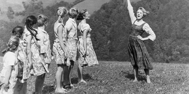 English actress and singer Julie Andrews as the young nun Maria, teaching the von Trapp children to sing