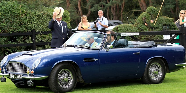 King Charles driving his Aston Martin car