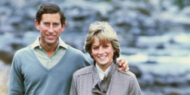 Princess Diana in a green outfit next to Prince Charles in a light blue sweater outside in Scotland