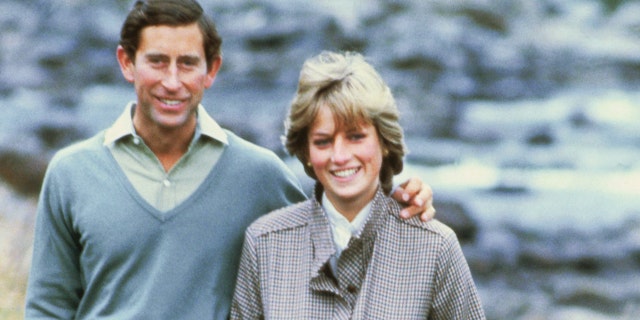 Princess Diana in a green outfit next to Prince Charles in a light blue sweater outside in Scotland