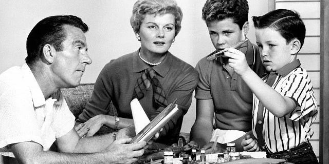 The cast of Leave It to Beaver sitting together with toy airplanes