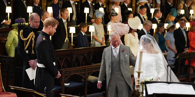 Meghan Markle being walked down the aisle on her wedding day