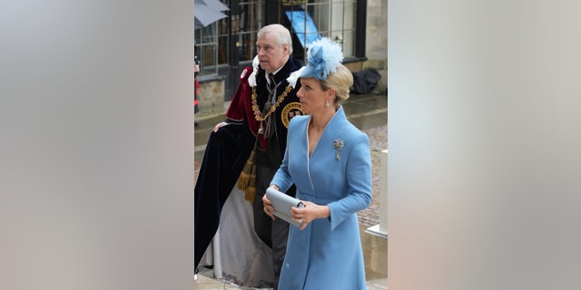 Prinz Andrew in königlichen Roben, der neben Zara Tindall in einem hellblauen Kleid läuft