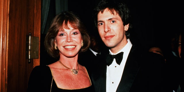 Mary Tyler Moore wearing a black dress next to Robert Levine wearing a tux