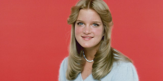 A close-up of Susan Olsen wearing a blue dress