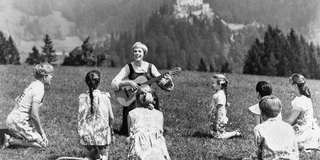 Julie Andrews playing guitar to her children castmates in The Sound of Music