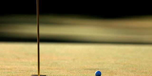 Golf ball next to hole