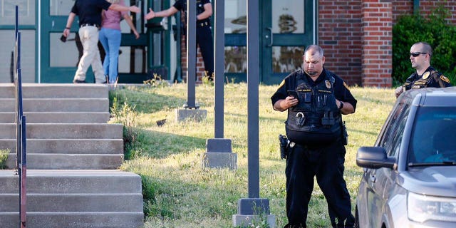 Law enforcement stand outside of Henryetta High School