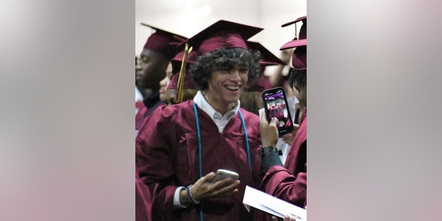 Gavin Guffey in a graduation gown