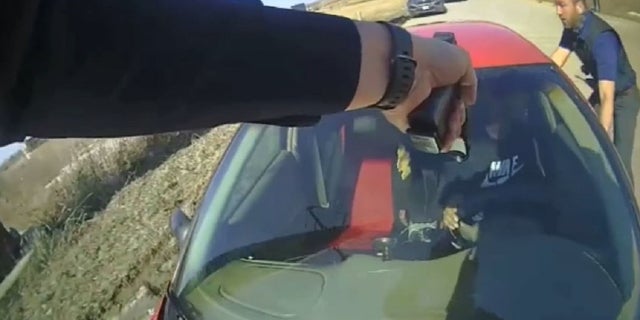 Cop on hood of car pointing gun at driver in Iowa