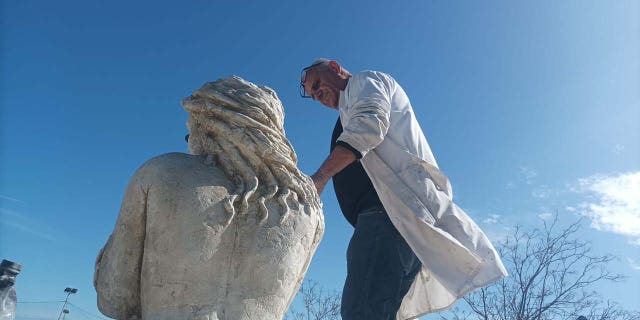 sculptor with his mermaid statue