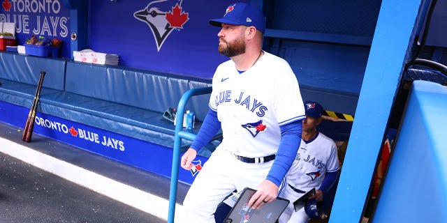 John Schneider walks into dugout