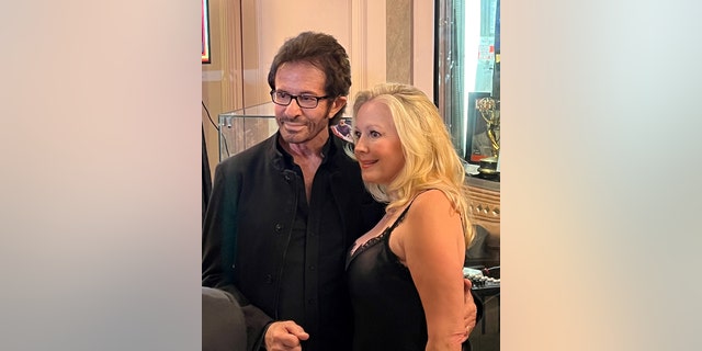 Kym Karath posing with George Chakiris, both wearing black