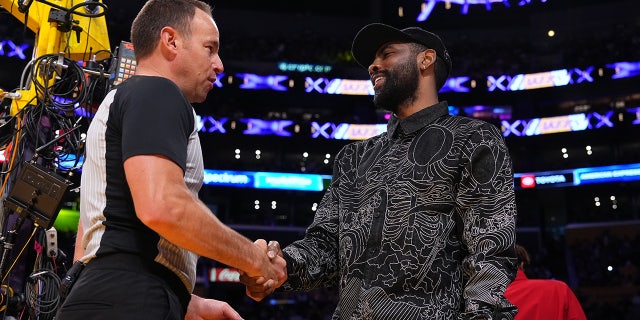 Referee Josh Tiven and Kyrie Irving shake hands