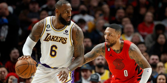 LeBron James dribbles against Damian Lillard