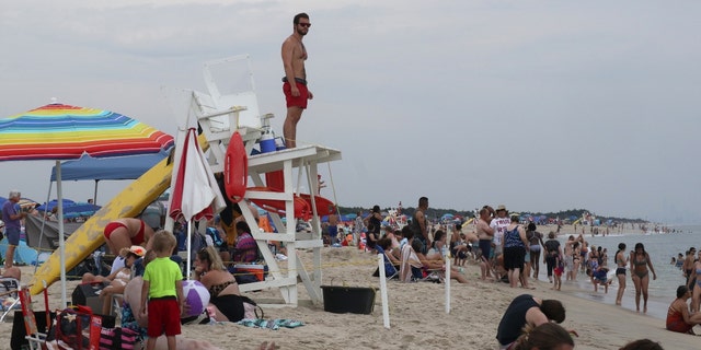 A lifeguard looks out at people swimming