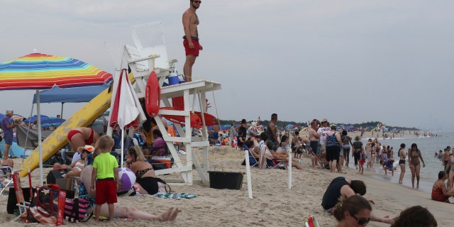 A lifeguard looks out at people swimming