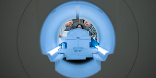 Alex Huth (left), Shelly Jin (center), and Jerry Tang (right) prepare to collect brain activity