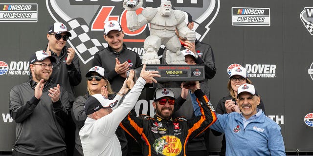 Martin Truex Jr holds up the trophy