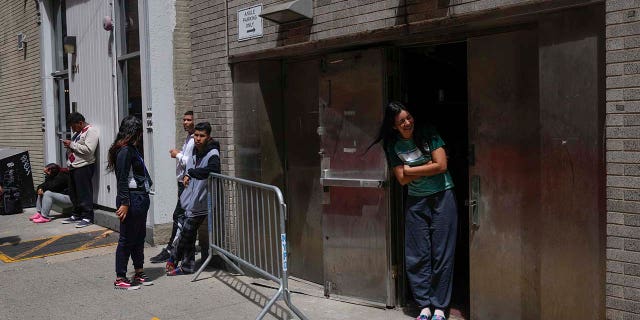 NYC Mayor Eric Adams asks to suspend 'right to shelter' for migrants 3 People stand by the door of a former NYPD police academy, where new immigrants to the city are being temporarily housed