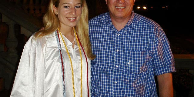 Natalee is in a white cap and gown as she stands with her father, Dave