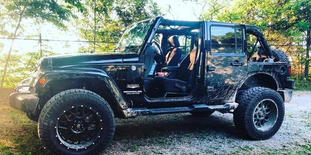 Black Jeep Wrangler with mud splashed on sides