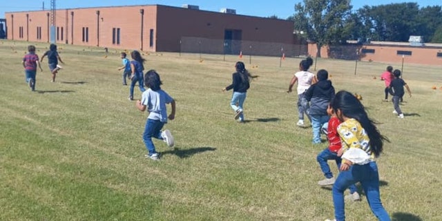 children playing in field outside school