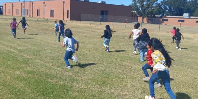 children playing in field outside school