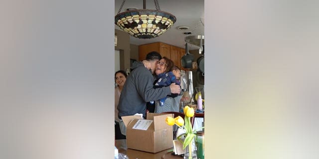 A woman hugs her son.