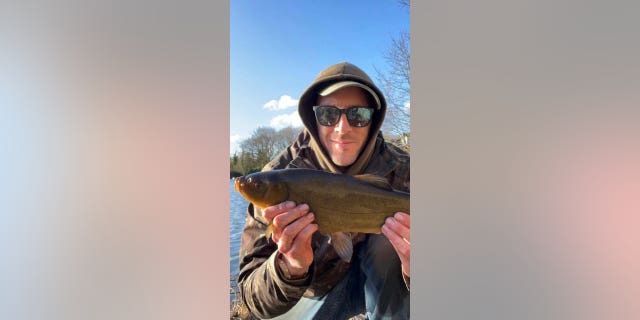 Andy Beeman holds a fish