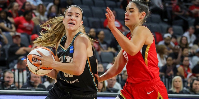 Sabrina Ionescu drives over Kelsey Plum