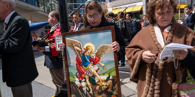 Christian protester with Archangel Michael painting