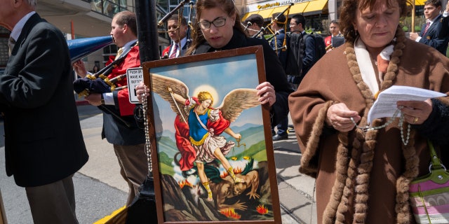 Christian protester with Archangel Michael painting