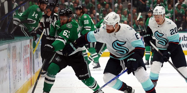 Evgenii Dadonov and Adam Larsson battle for the puck