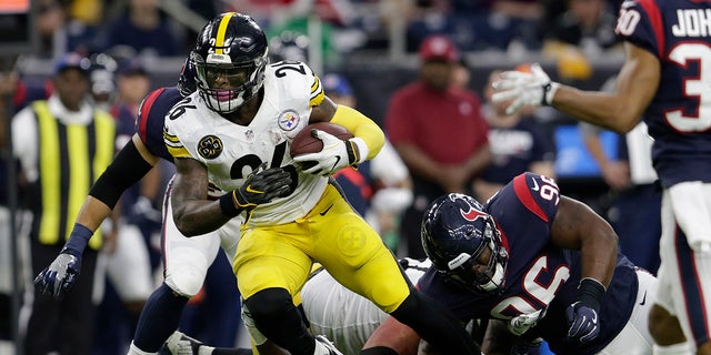 Le'Veon Bell runs with the ball during a game