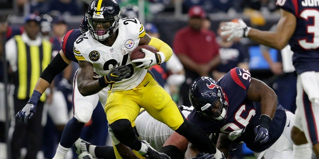 Le'Veon Bell runs with a soccer ball during a game