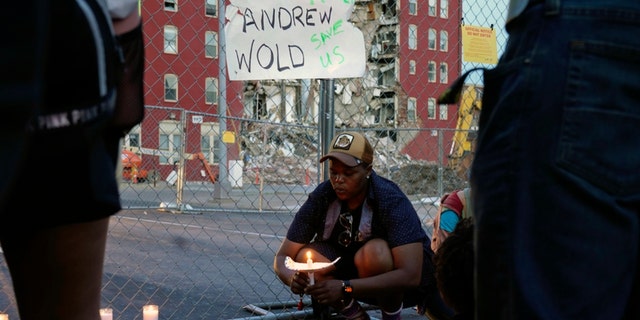 A vigil outside the scene of where an apartment building partially collapsed