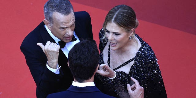 Tom Hanks talks to a staff member at Cannes